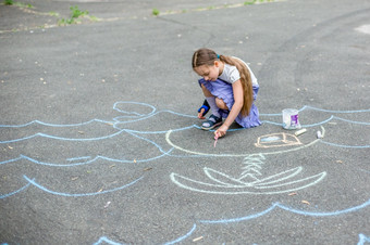 可爱的男孩和女孩画与粉笔的人行道上的公园夏天活动为孩子们有创意的画孩子与蓝色的粉笔的路可爱的男孩和女孩画与粉笔的人行道上的公园