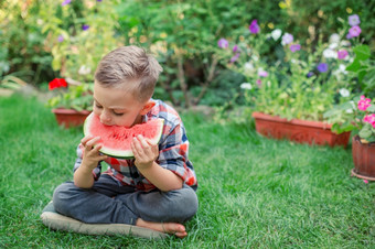 快乐孩子吃西瓜的花园孩子们吃水果在户外健康的零食为孩子们小男孩玩的花园咬片水瓜快乐男孩吃西瓜的花园孩子们吃水果在户外健康的零食为孩子们