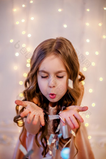 肖像小女孩与卷曲的头发圣诞节夏娃的新一年将带礼物快乐的情绪期待惊喜肖像小女孩与卷曲的头发圣诞节夏娃的新一年将带礼物