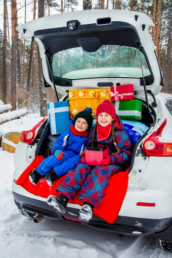 快乐的孩子们享受许多圣诞节礼物车树干冷冬天雪天气快乐的孩子们享受许多圣诞节礼物车树干