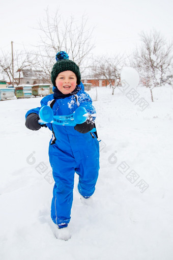 快乐男孩造型和抛出雪球冬天游戏的新鲜的空气冬天假期快乐男孩造型和抛出雪球冬天游戏的新鲜的空气