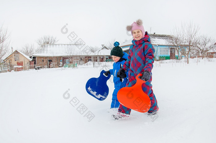 快乐男孩和女孩走山滑雪橇冬天冬天游戏的新鲜的空气冬天假期快乐男孩和女孩走山滑雪橇冬天冬天游戏的新鲜的空气