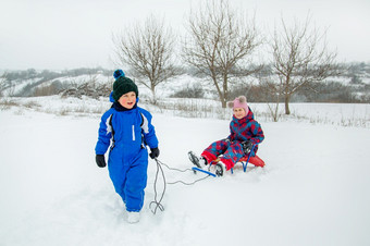 快乐男孩和女孩滑雪橇从山<strong>冬天冬天</strong>游戏在户外<strong>冬天</strong>假期快乐男孩和女孩滑雪橇从山<strong>冬天冬天</strong>游戏在户外
