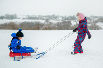 快乐男孩和女孩<strong>滑雪橇</strong>从山冬天冬天游戏在户外冬天假期快乐男孩和女孩<strong>滑雪橇</strong>从山冬天冬天游戏在户外
