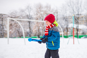 快乐男孩玩与雪雪冬天走使雪球的公园冬天户外游戏快乐男孩玩与雪雪冬天走使雪球的公园