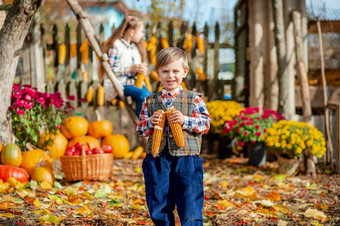 肖像男孩与玉米他的手孩子们选择成熟的蔬菜和水果的农场秋天的概念的秋天收获的农场肖像男孩与玉米他的手孩子们选择成熟的蔬菜和水果的农场秋天