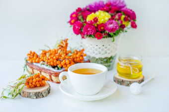 温暖的甜蜜的有机茶与海鼠李浆果百里香和蜂蜜白色背景自然照明水平作文与复制空间概念美简单白色背景自然照明温暖的甜蜜的有机茶与海鼠李