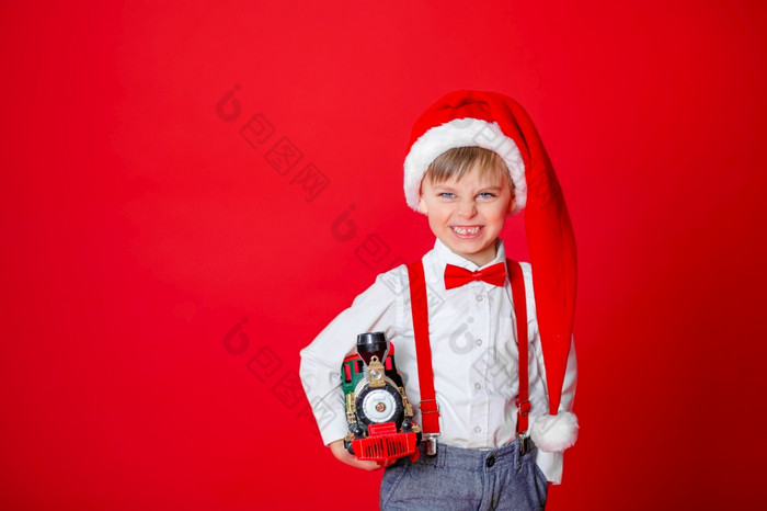可爱的愤怒的小男孩圣诞老人老人他红色的背景快乐童年与梦想和礼物可爱的愤怒的小男孩圣诞老人老人他红色的背景
