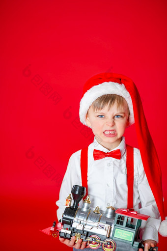 可爱的愤怒的小男孩圣诞老人老人他红色的背景快乐童年与梦想和礼物可爱的愤怒的小男孩圣诞老人老人他红色的背景