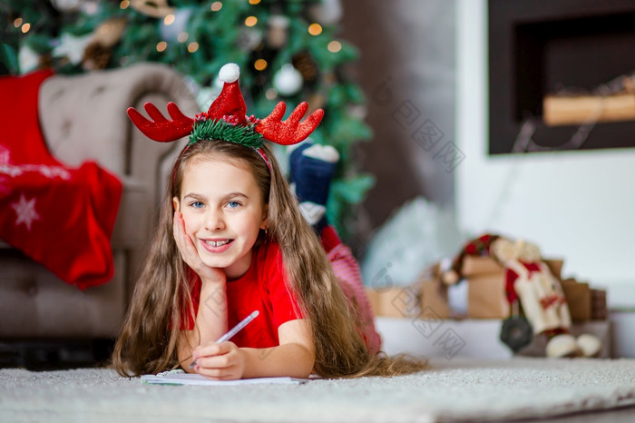 有趣的可爱的高加索人女孩左撇子写信圣诞老人老人附近的圣诞节树快乐童年时间奇迹和欲望快乐圣诞节有趣的可爱的高加索人女孩左撇子写信圣诞老人老人附近的圣诞节树快乐童年时间奇迹和欲望