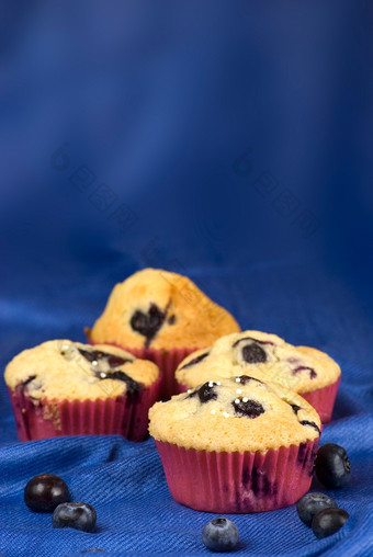 自制的蓝莓松饼在蓝色的织物背景