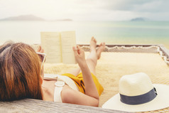 女人阅读书吊床海滩免费的时间夏天假期