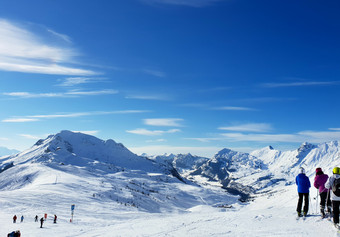 滑雪者滑<strong>雪山</strong>坡上法国阿尔卑斯山脉下<strong>蓝色</strong>的<strong>天空</strong>