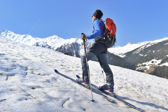 徒步旅行者巡回演出滑雪攀爬雪山阳光明媚的和温暖的一天