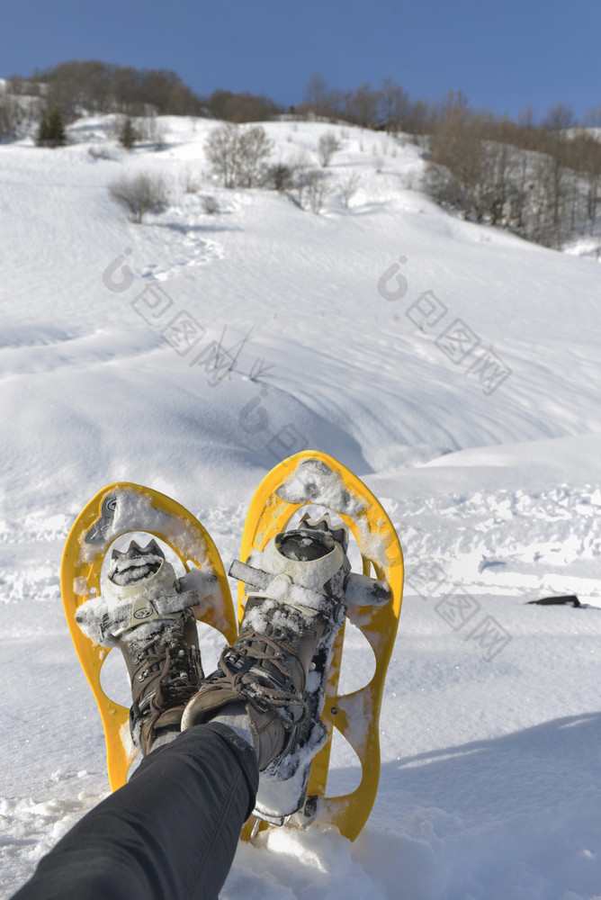 脚女人与雪鞋坐着的雪