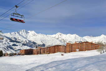 滑雪山坡上法国阿尔卑斯山脉度假胜地和椅子电梯下蓝色的天空