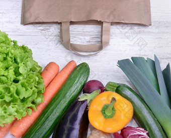 前视图各种各样的色彩斑斓的蔬菜和纸袋白色表格新鲜的色彩斑斓的蔬菜白色表格和纸袋
