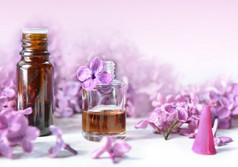 瓶至关重要的石油和香与紫色的淡紫色花背景瓶至关重要的石油和香与紫色的淡紫色花背景