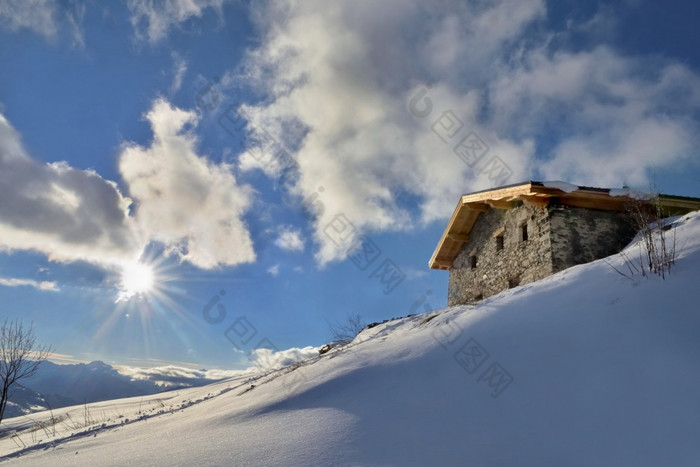 传统的高山的小木屋的前雪山下日出的天空传统的高山的小木屋的前雪山下日出的天空