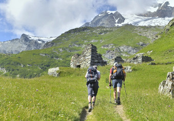 两个徒步旅行者与背包攀爬小径高山冰川夏天
