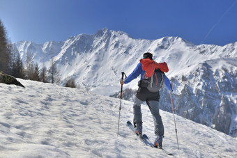男人。攀爬雪山巡回演出滑雪下蓝色的天空