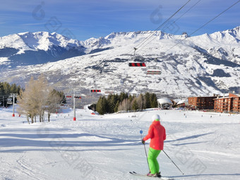 滑雪滑雪山坡上法国阿尔卑斯山脉度假胜地和椅子电梯下蓝色的天空
