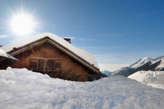 太阳在山木的小木屋的雪