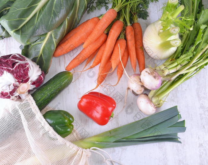 前视图蔬菜可重用的袋在其他新鲜的蔬菜白色表格蔬菜可重用的袋在其他新鲜的蔬菜白色表格
