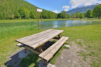 木野餐表格的草的边缘湖休闲公园的法国阿尔卑斯山脉野餐表格的边缘湖休闲高山公园