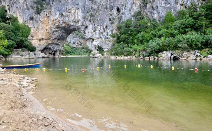 船和浮点数河的峡谷的阿尔代什法国和拱悬崖背景