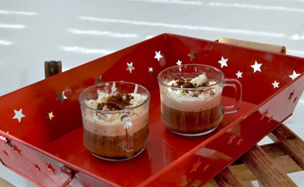 杯卡布奇诺咖啡放置红色的托盘木雪橇的雪杯卡布奇诺放置红色的托盘木雪橇的雪