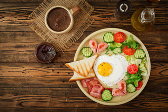 早餐情人节rsquo一天炸蛋的形状心祝酒香肠培根和新鲜的蔬菜英语早餐杯咖啡前视图