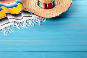 <strong>墨西哥帽子</strong>和传统的<strong>墨西哥</strong>披肩毯子铺设老蓝色的画松木地板上空间为复制
