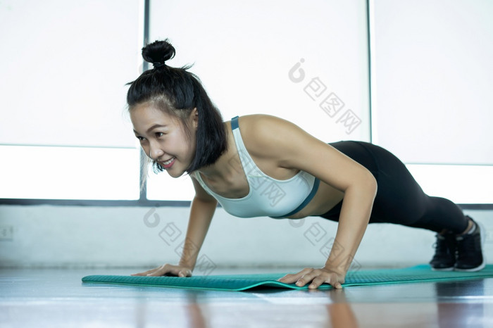 女人做健身培训健身女人做推联合包裹培训席年轻的女人做俯卧撑的健身房肌肉发达的女做俯卧撑锻炼席健身房