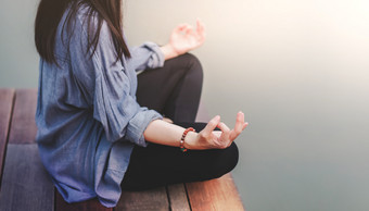 年轻的女人实践瑜伽户外坐着莲花位置不插电生活和精神健康概念苏哈萨那的姿势和冥想