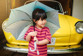 肖像快乐孩子们与伞之前郊游保护雨阳光夏天多雨的季节概念小可爱的年老女孩幸福时刻