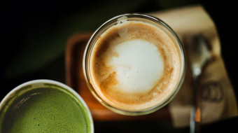 特写镜头热咖啡拿铁和火柴绿色茶杯表格前视图咖啡馆餐厅场景