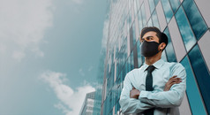 新冠病毒情况业务概念商人与安全面具站的城市受保护的和哪健康强调出由于电晕病毒看成的天空