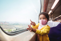旅行新正常的生活方式概念快乐孩子们穿外科手术保护面具内部火车而旅行与她的父坐着宽玻璃窗口取视图