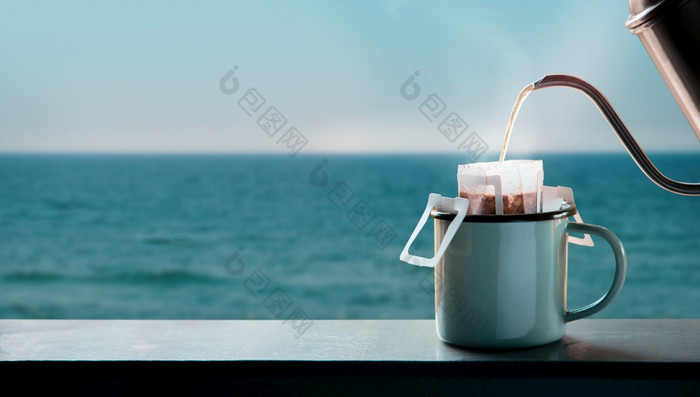 滴咖啡的海一边早....使热喝倒热水从水壶成即时咖啡滴袋的阳台放松享受与和谐生活生活方式