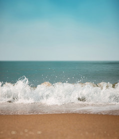 沙子海滩和硬波夏天阳光明媚的一天蓝色的海洋和天空背景低角视图焦点水涟漪花式