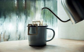 滴咖啡的窗口早....多雨的一天使热喝倒热水从水壶成即时咖啡滴袋放松享受与和谐生活生活方式