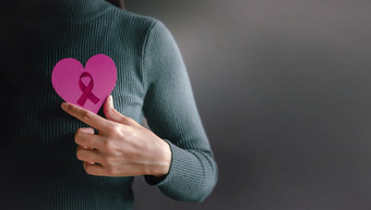 爱健康哪捐赠和慈善机构概念乳房癌症意识世界癌症幸存者一天关闭女人持有心与丝带她的乳房