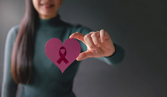 爱健康哪癌症捐赠和慈善机构概念乳房癌症意识关闭微笑志愿者女人持有心形状与癌症丝带标志纸