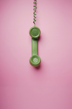 绿色古董复古的电话手机汉芬粉红色的背景老对象从技术和沟通的过去的清洁色彩鲜艳的和最小的