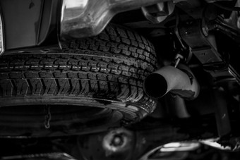备用轮胎下的车附近排气管备用轮橡胶产品汽车检查之前旅行概念卡车备用轮胎概念改变轮胎服务业务汽车行业