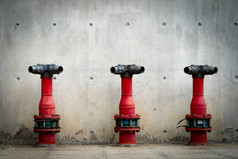 三个火安全泵水泥地板上混凝土建筑洪水系统消防系统管道火保护红色的火泵前面混凝土墙高压力火安全泵