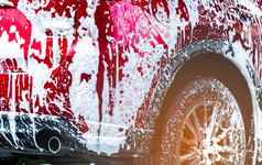 红色的紧凑的运动型多功能车车与体育运动和现代设计洗与肥皂车覆盖与白色泡沫车哪服务业务概念车洗与泡沫之前玻璃打蜡和玻璃涂层汽车