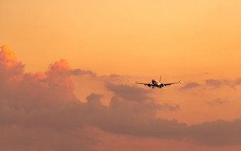 商业航空公司乘客飞机着陆机场与美丽的日落天空和云到来飞行飞机飞行行为着陆飞机开放光的晚上飞行