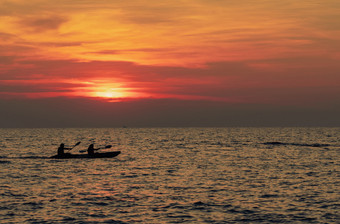 轮廓夫妻是皮划艇的海日落皮艇的热带海日落浪漫的夫妇旅行夏天假期冒险活动浪漫的夫妻美丽的日落天空